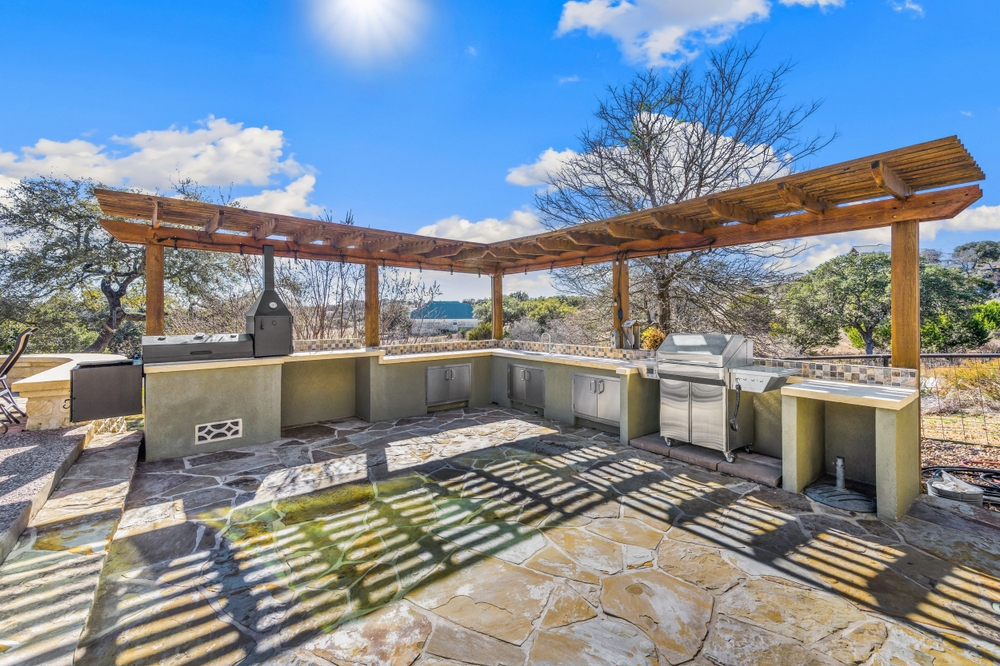 A,back,patio,with,a,grill,and,outdoor,kitchen